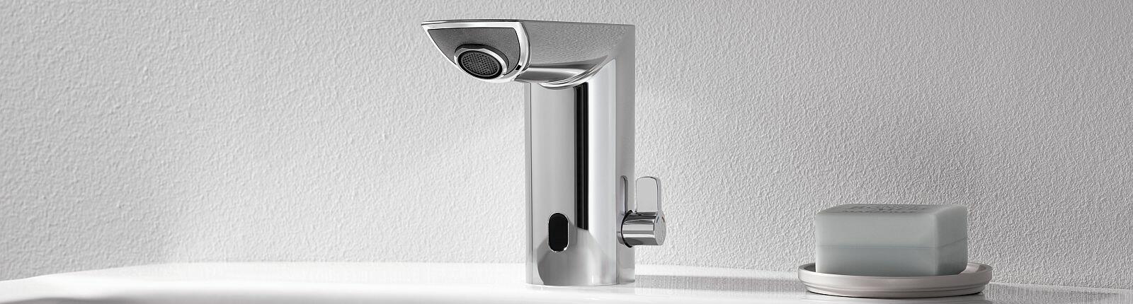 Silberne Elektronik-Armatur von GROHE und Seife